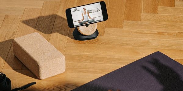 Yoga mat on a dark wooden floor in studio.